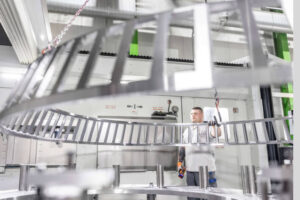 Ein HSP Mitarbeiter entnimmt einen Großlagerkäfig nach der Fräsoperation aus der Maschine.