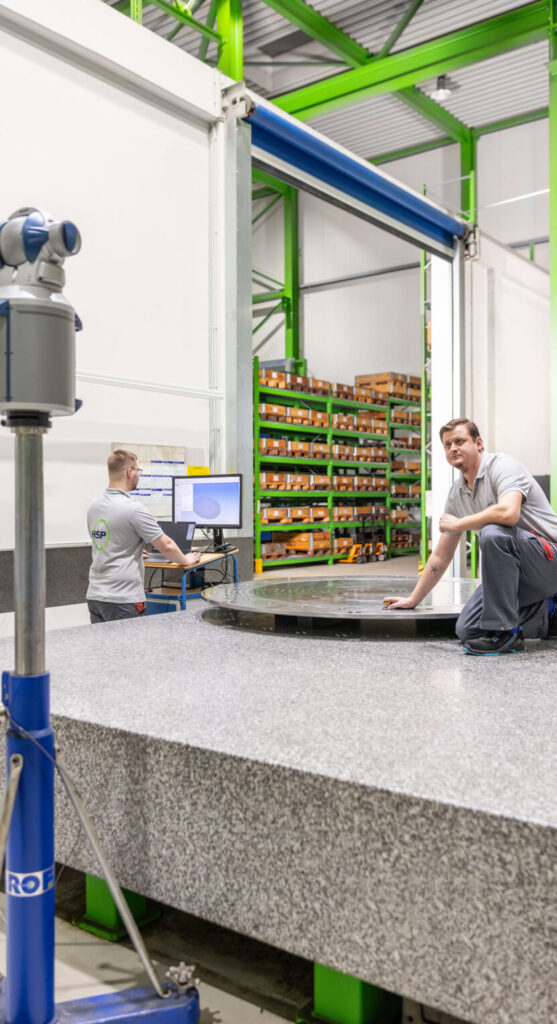 Zwei Mitarbeiter bereitet die HSP Messanlage für die Vermessung eines Bauteils mit dem Laser vor und anhand eines 3D Modells vor.