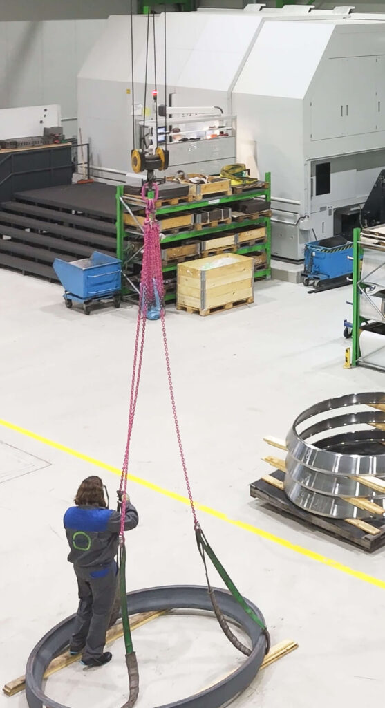 Ein HSP Mitarbeiter bereitet einen sehr großen Walzring vor, mit dem Kran in die Maschine gehoben zu werden.