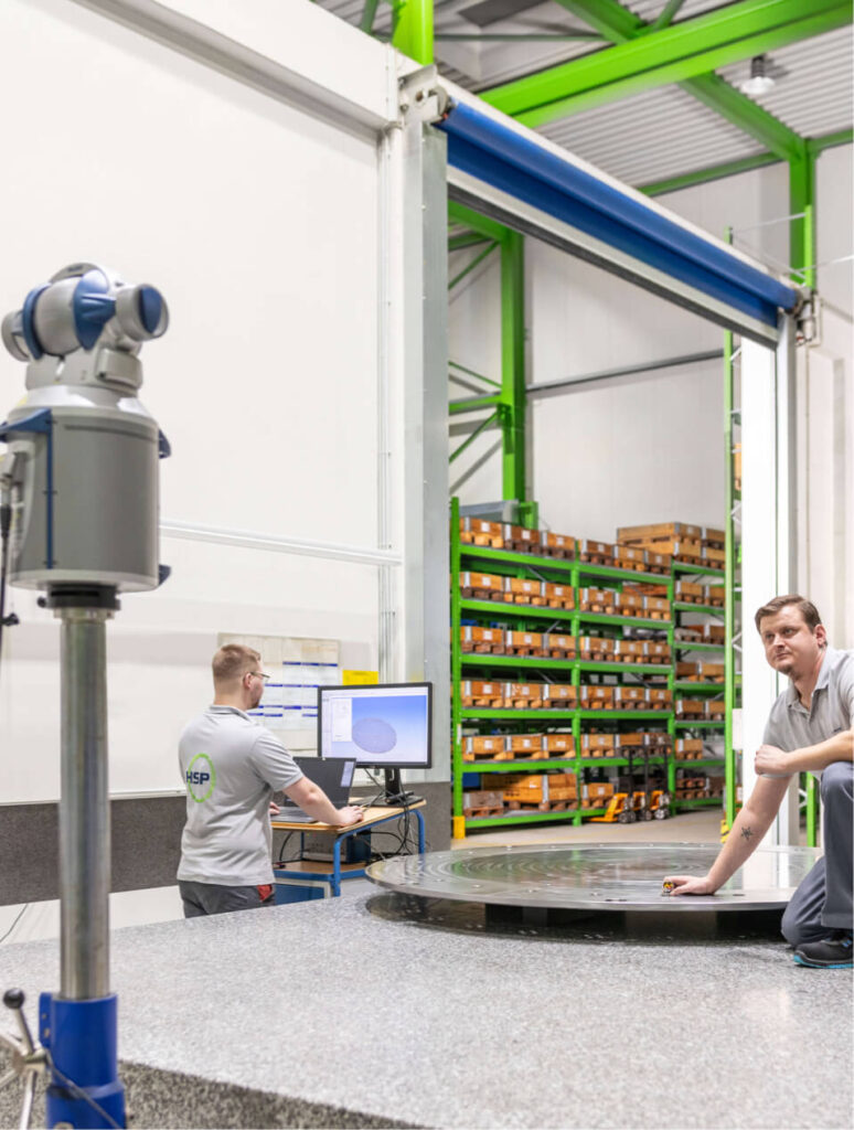 Mitarbeiter bereiten das Messen eines Bauteils mittels Laser per 3D-Modell vor.